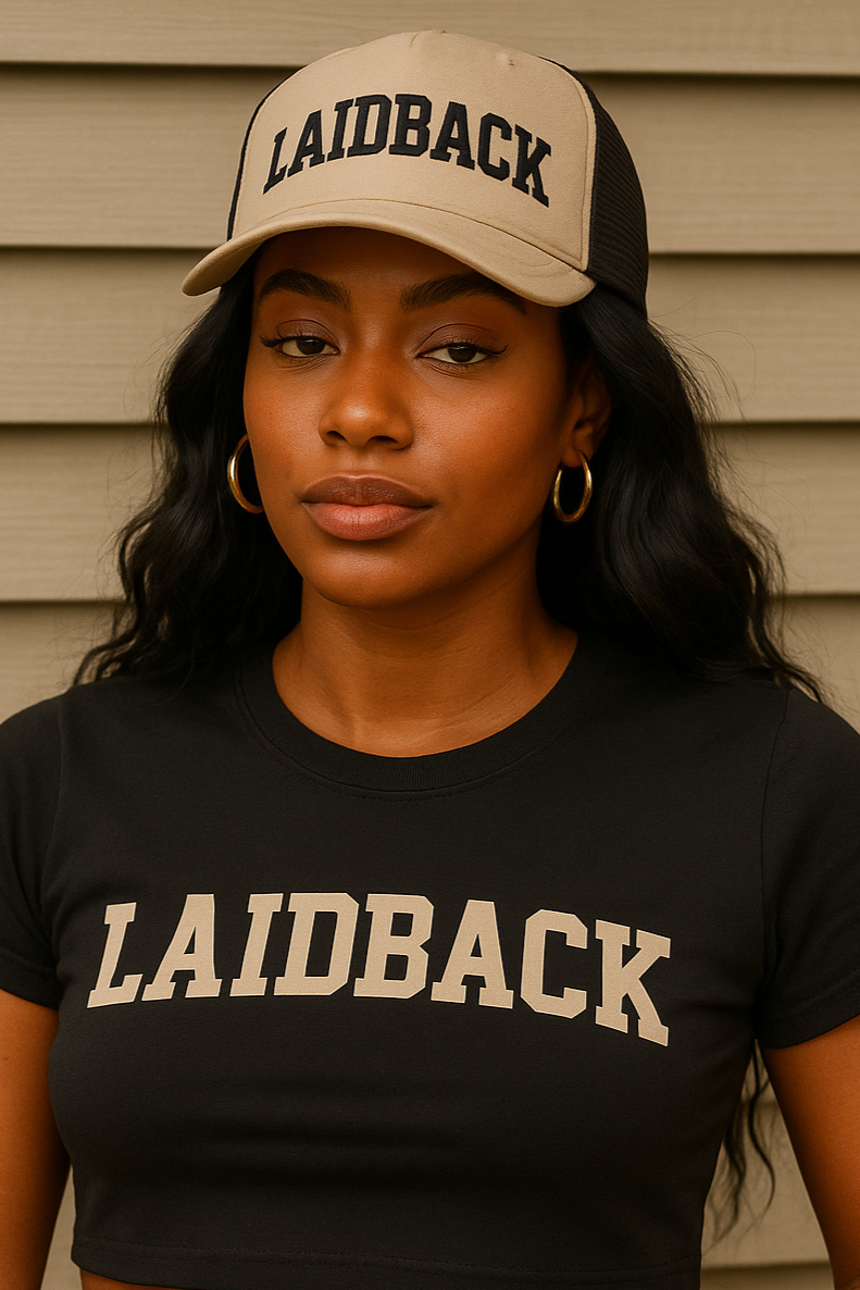 Person wearing a black 'Laidback' t-shirt, beige cap, and fanny pack against a neutral background
